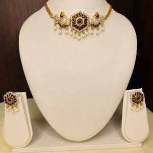 Gold-toned Peacock Kemp Necklace Set with Pearl Drops – choker-style necklace featuring peacock motifs, red and green kemp stones, and pearl tassel accents, displayed on an off-white velvet bust – South Indian traditional jewellery by Santosree Collective